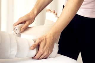 Physiotherapeut führt Lymphologische Physiotherapie an Patient:in durch